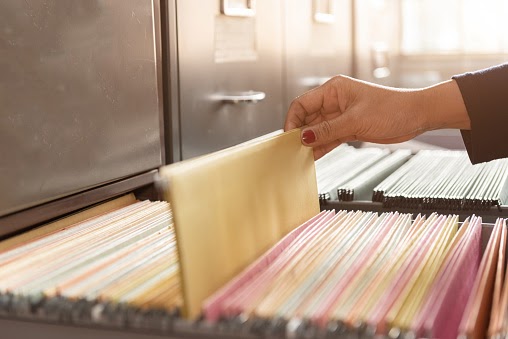 a woman sifting through a filing cabinet