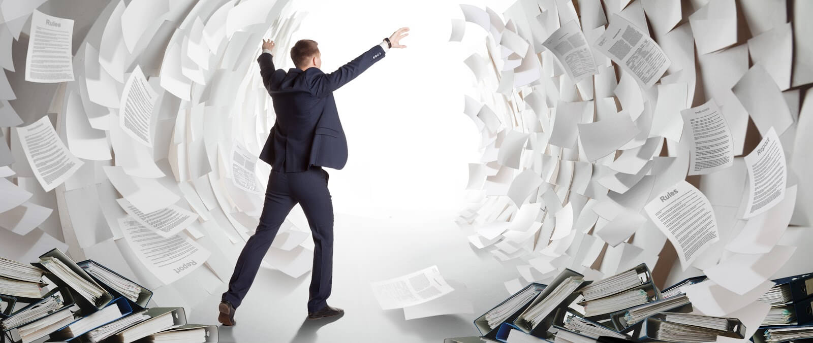 a man looking overwhelmed by a stack of paper