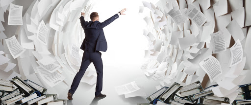 a man overwhelmed by the amount of documents around him