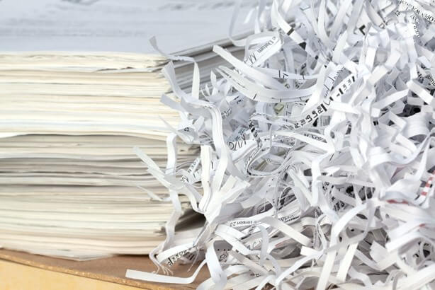 Paper shredded next to a pile of unshredded paper