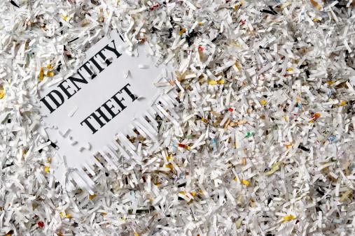 Identity Theft words surrounded by shredded paper